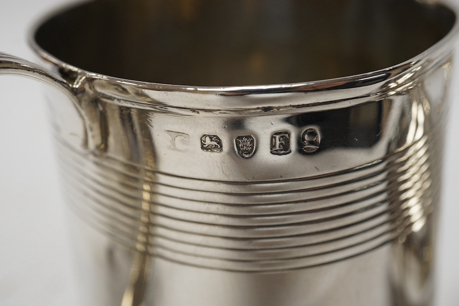 A George III silver cream jug, marks rubbed, a George III silver christening mug, London, 1801 and a William IV silver melon shaped mustard pot, John, Henry & Charles Lias, London, 1835. Condition - poor to fair